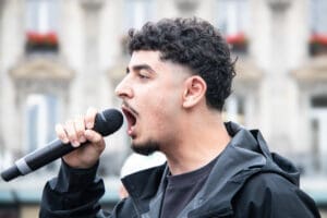 Young Palestinian activist leads chants during Paris rally for G idir hakim photographe paris