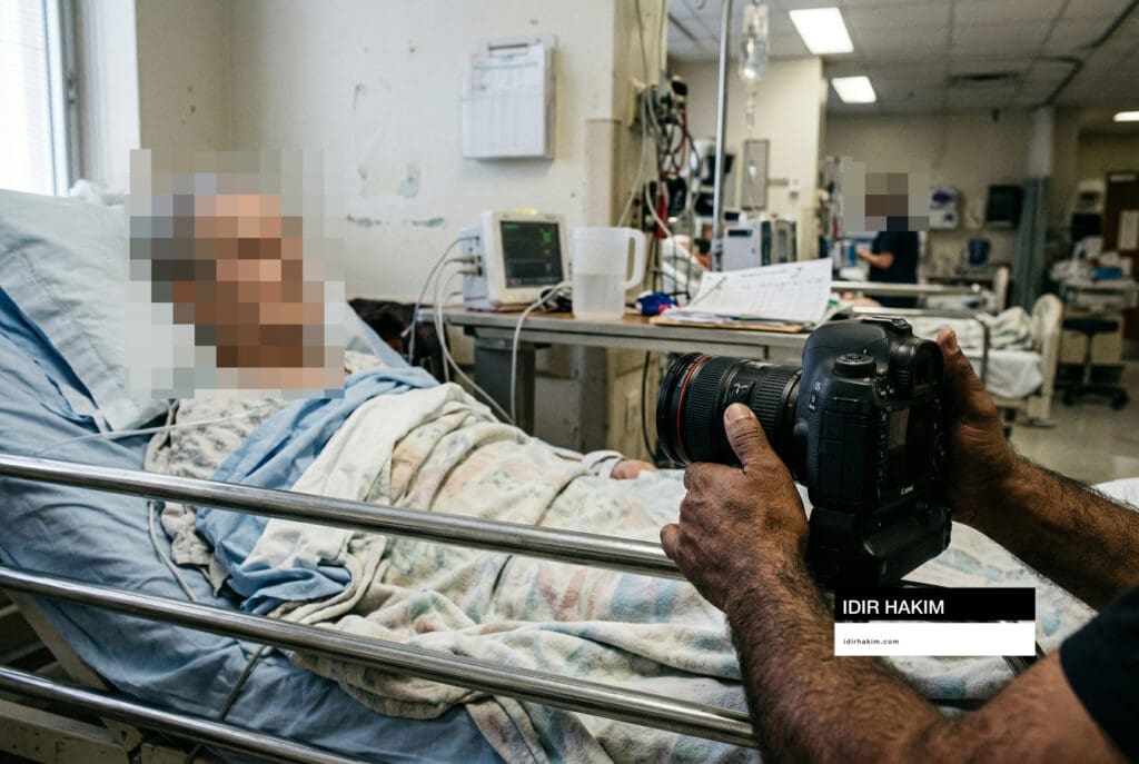 Plan rapproché sur les gestes du photographe au chevet d'un malade hospitalisé, précision technique.